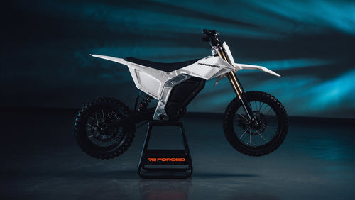 A white and black electric dirt bike on a black stand, photographed in a dark studio with blue lighting. The bike has visible branding including 'FORGED' on the stand and 'RACE' on the side panel. electric dirt bike

ebike moto

electric pit bike

light electric motorcycle

off road electric bike

adult electric dirt bike

high performance e-dirt bike surron alternative

talaria vs surron

best electric pit bike for adults

custom electric dirt bike builds

street legal electric dirt bike

forged frame elec