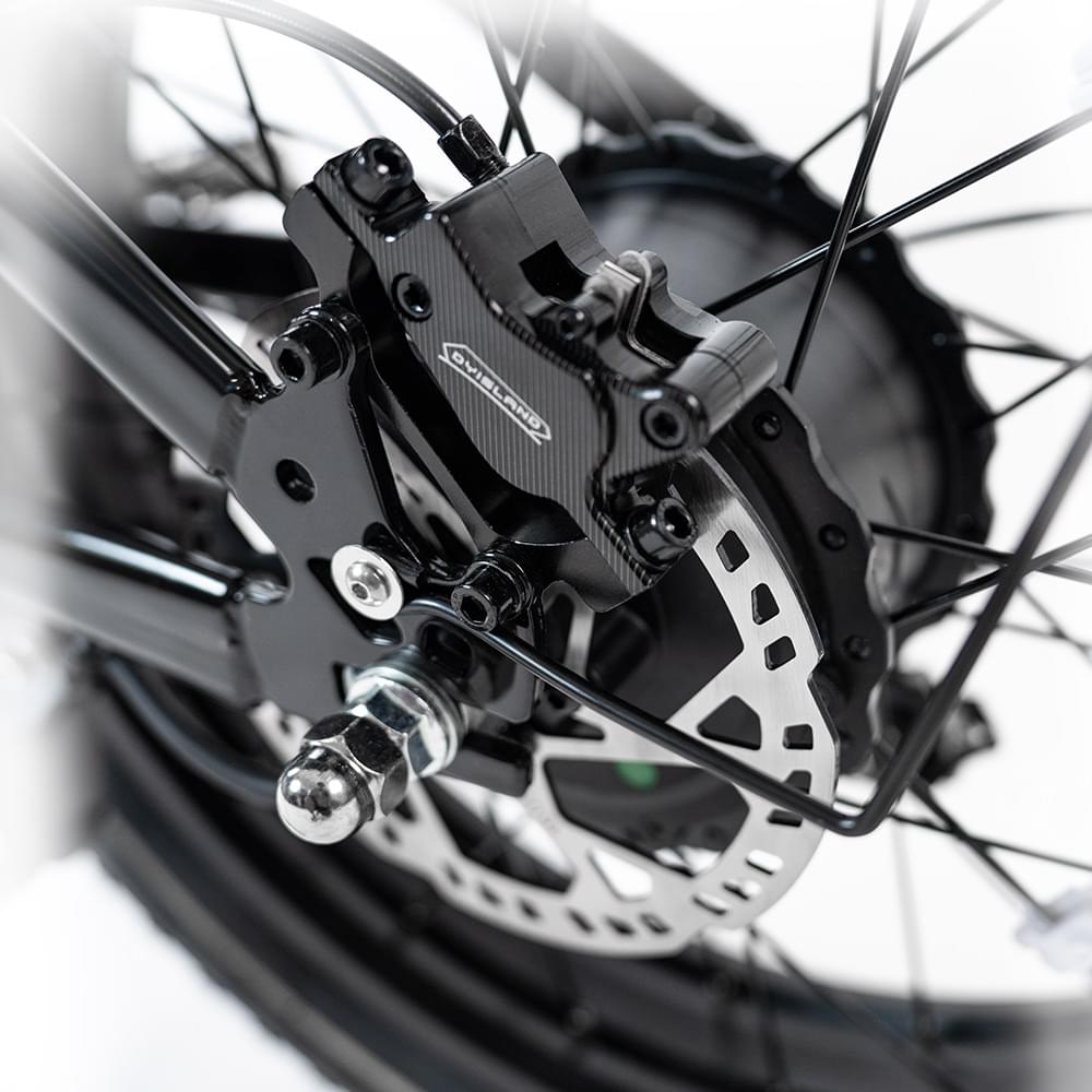 close-up view of hydraulic disc brake of HappyRun G70 750W fat-tire electric cargo bike in matte black color, Adult e-bike featuring a dual battery setup, powerful dual-motor system, aluminum alloy cargo-ready frame, front suspension fork, padded rear cargo seat with backrest, integrated rear cargo rack, hydraulic disc brakes,7-speed, front LED headlight, and backlit LCD display, Class 3 electric bike built for hauling gear and long-range rides. Similar to Macfox Electric Bicycle 48V 500w E-Bike - X7.