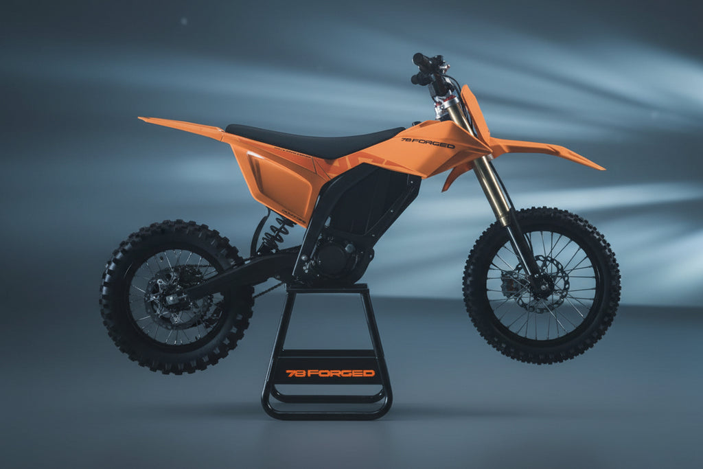 ebike moto
electric pit bike
light electric motorcycle
off road electric bike
adult electric dirt bike
high performance e-dirt bike surron alternative
talaria vs surron
Dust Moto
best electric pit bike for adults
custom electric dirt bike builds
street legal electric dirt bike
forged frame electric moto long raAn orange and black electric dirt bike on a black stand with the brand name '78 FORGED' visible on both the stand and the bike's side panel, set against a dark, atmospheric background with blue light.